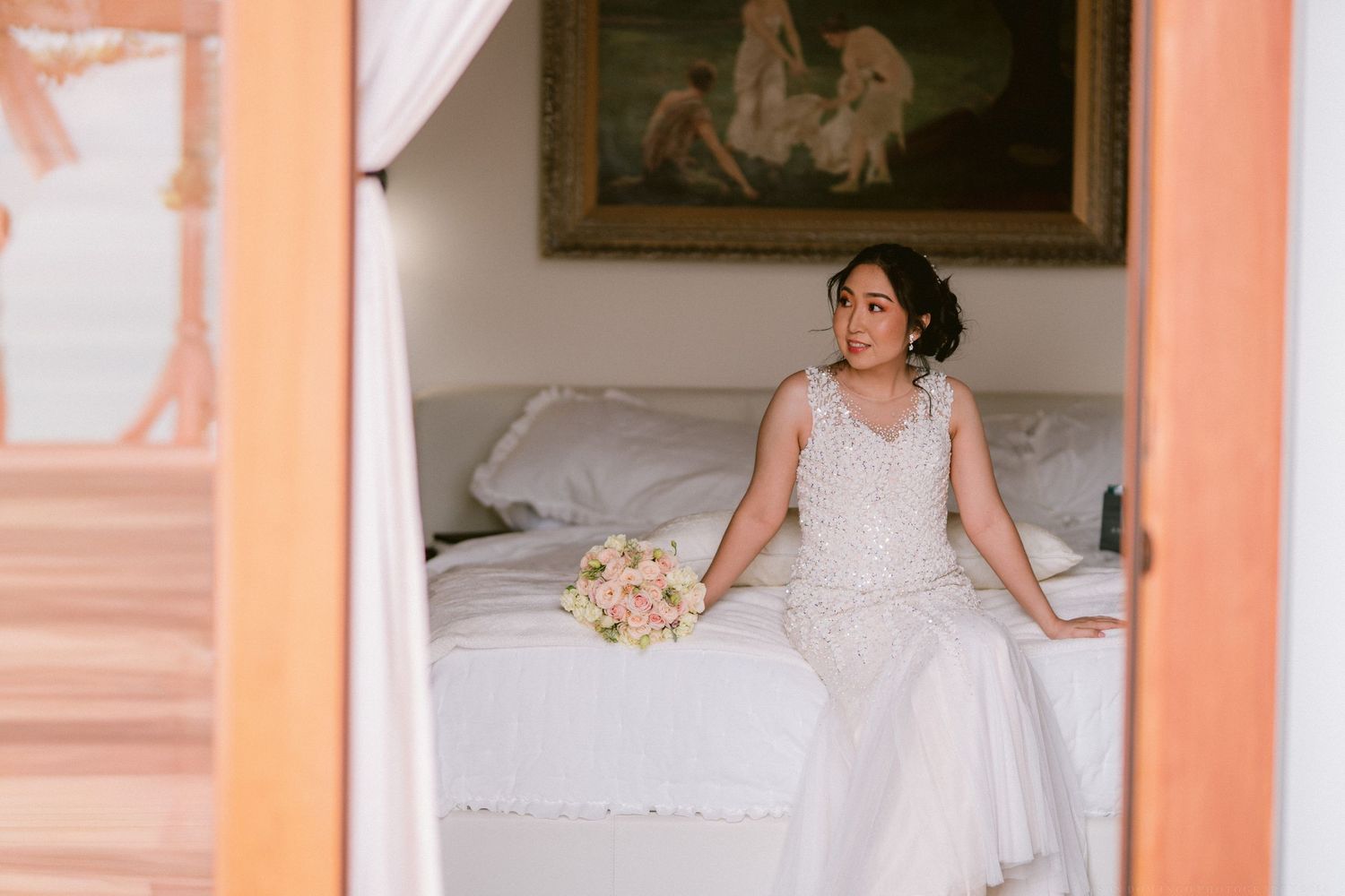 Wedding preparations in a peach-colored room with vintage decor.