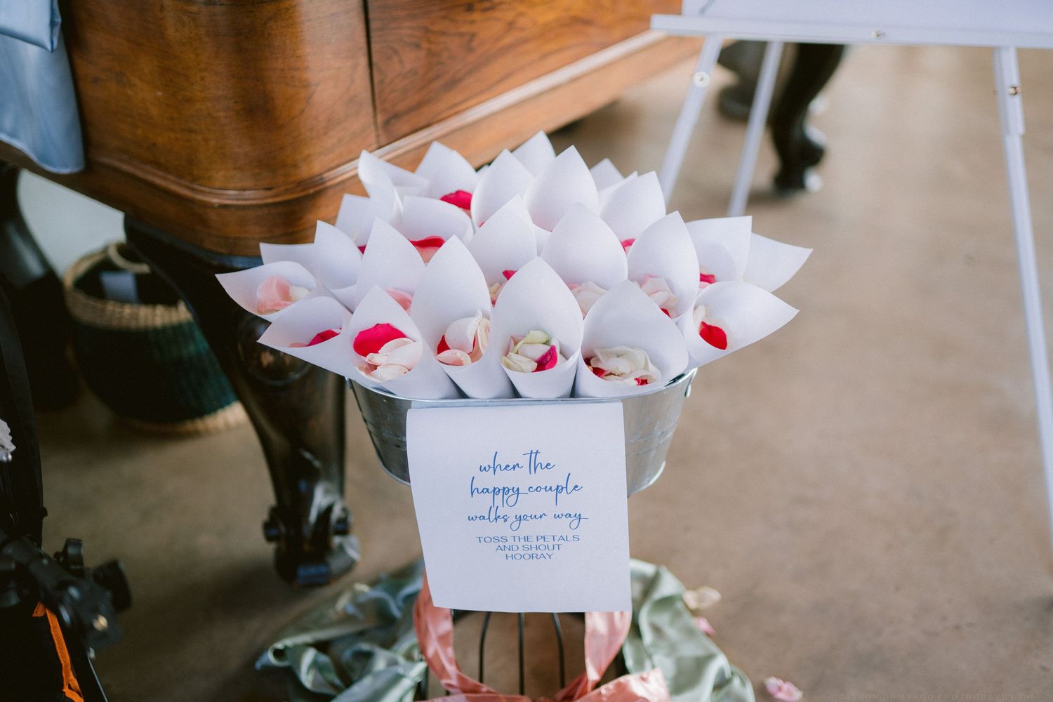 White paper wedding favor cones arranged neatly on a dark wooden surface.