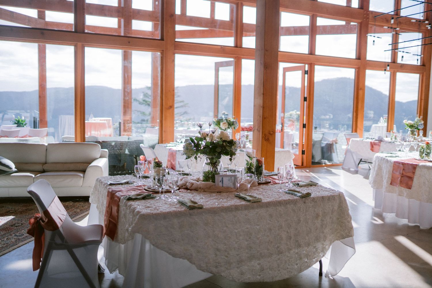 An elegant reception room with panoramic windows overlooking mountain scenery.