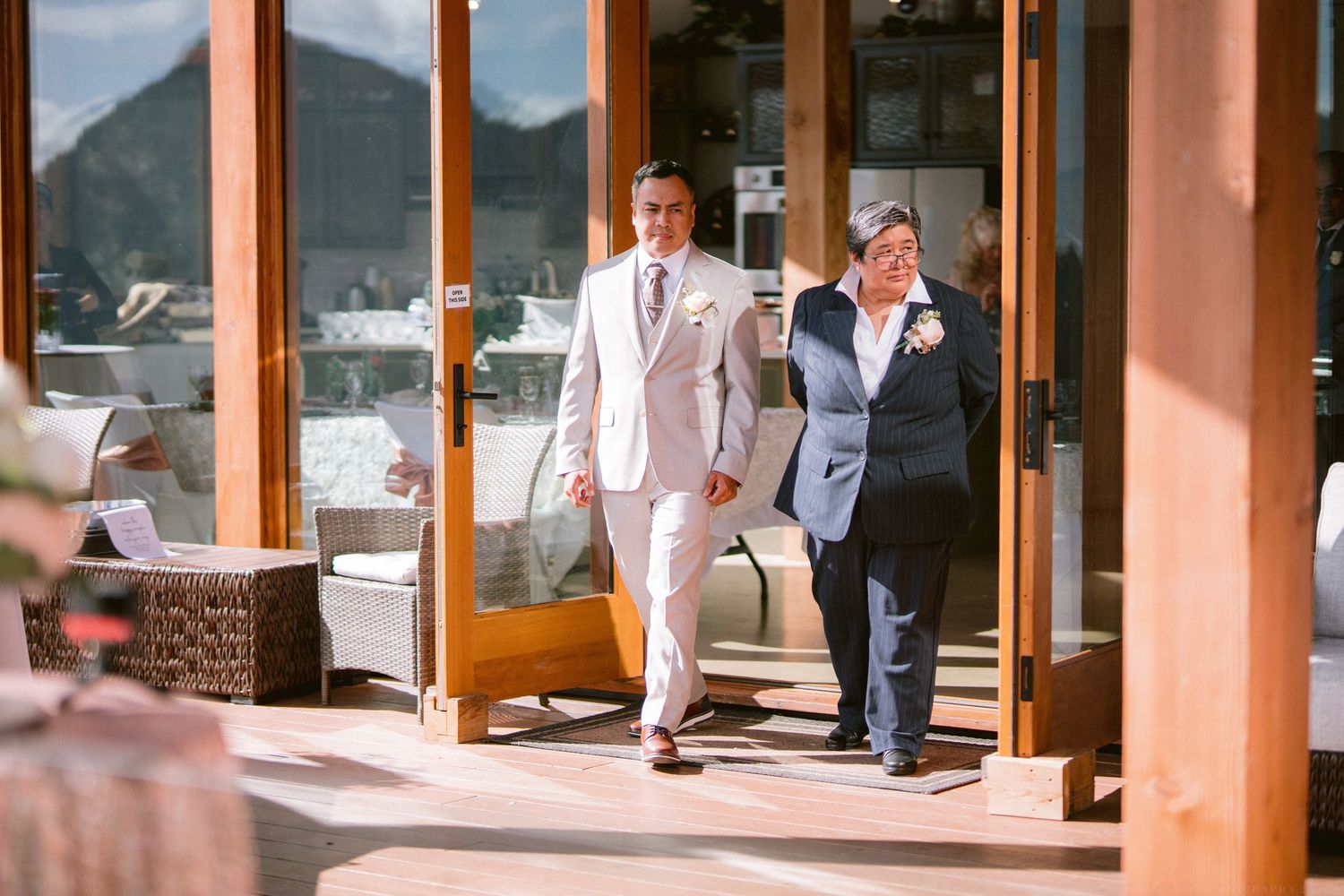 Wedding ceremony venue with wooden beams and large windows overlooking mountain scenery.