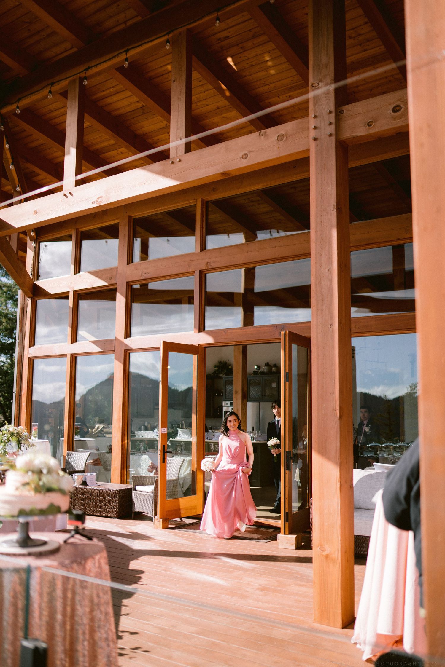 Modern wooden venue with mountain views and pink wedding decor.