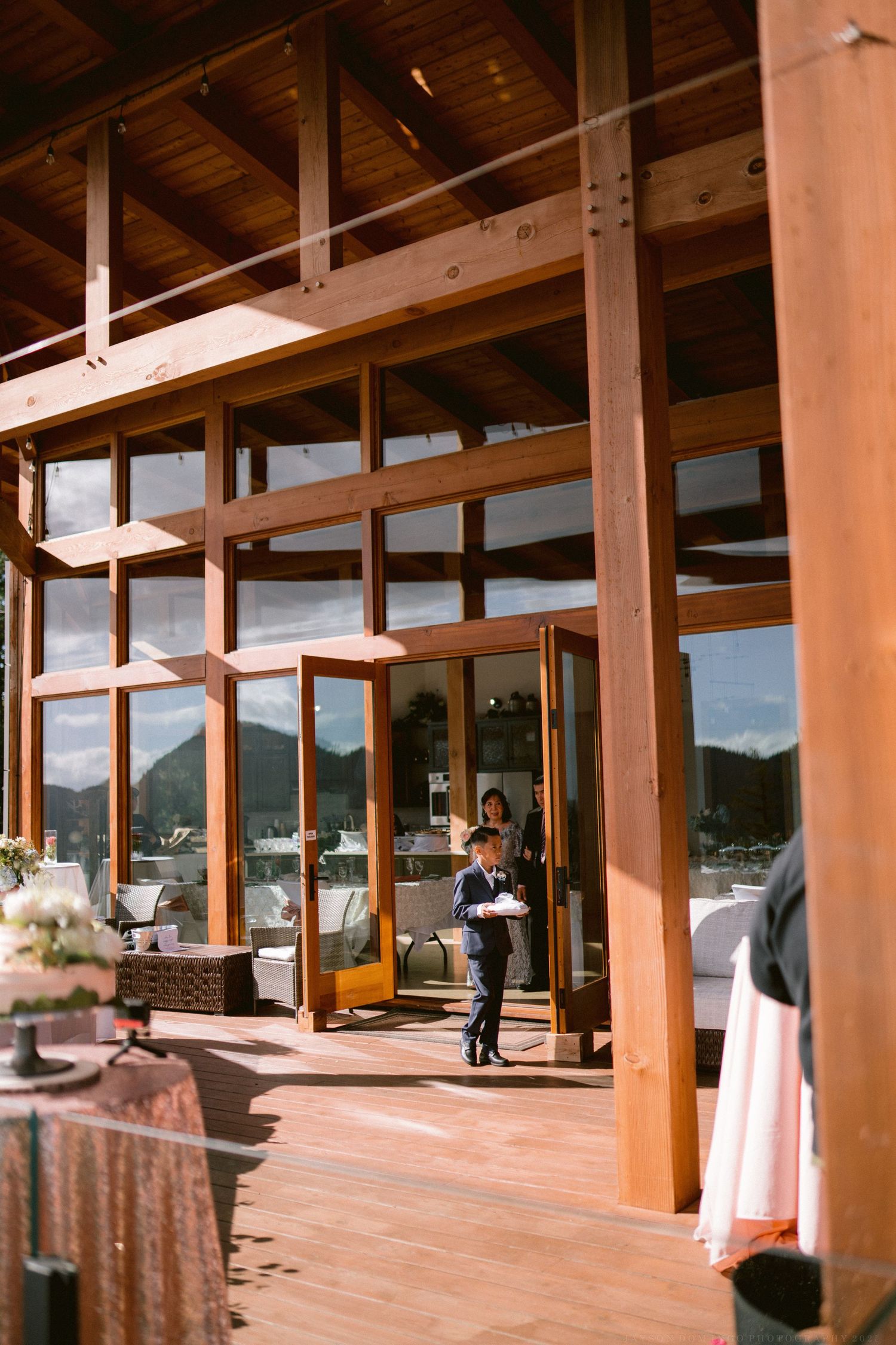 Modern event venue with wooden beams and large windows overlooking mountain views.