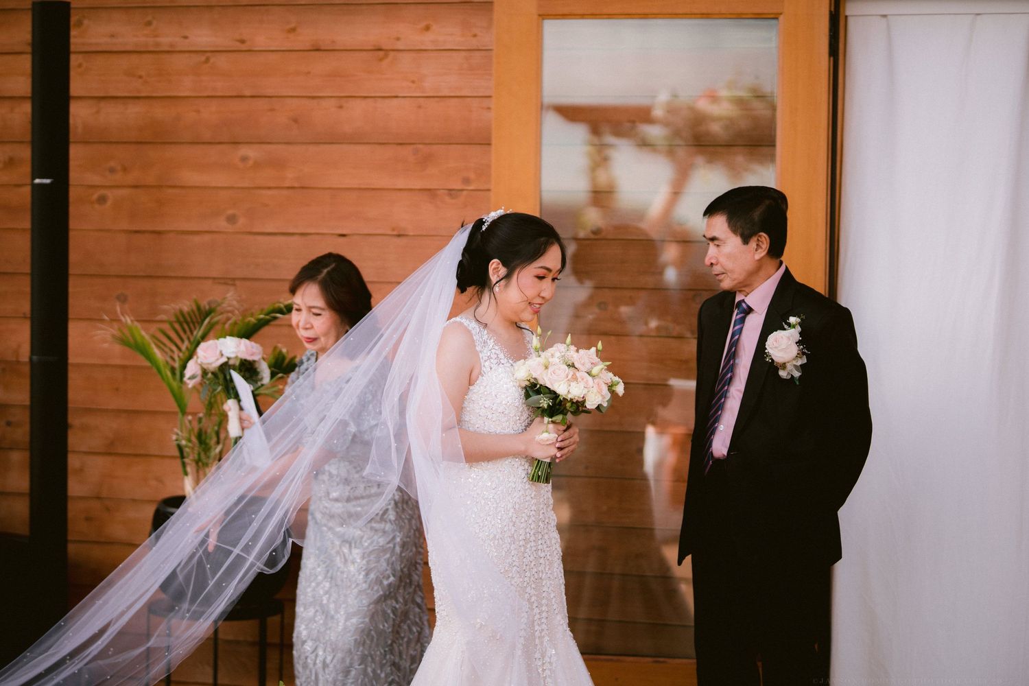 Wedding ceremony in a rustic wooden venue with guests watching the couple exchange vows.