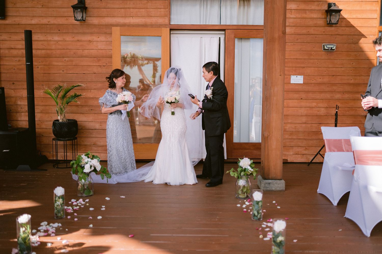 Wedding ceremony setup with rustic wooden walls and white decorations.