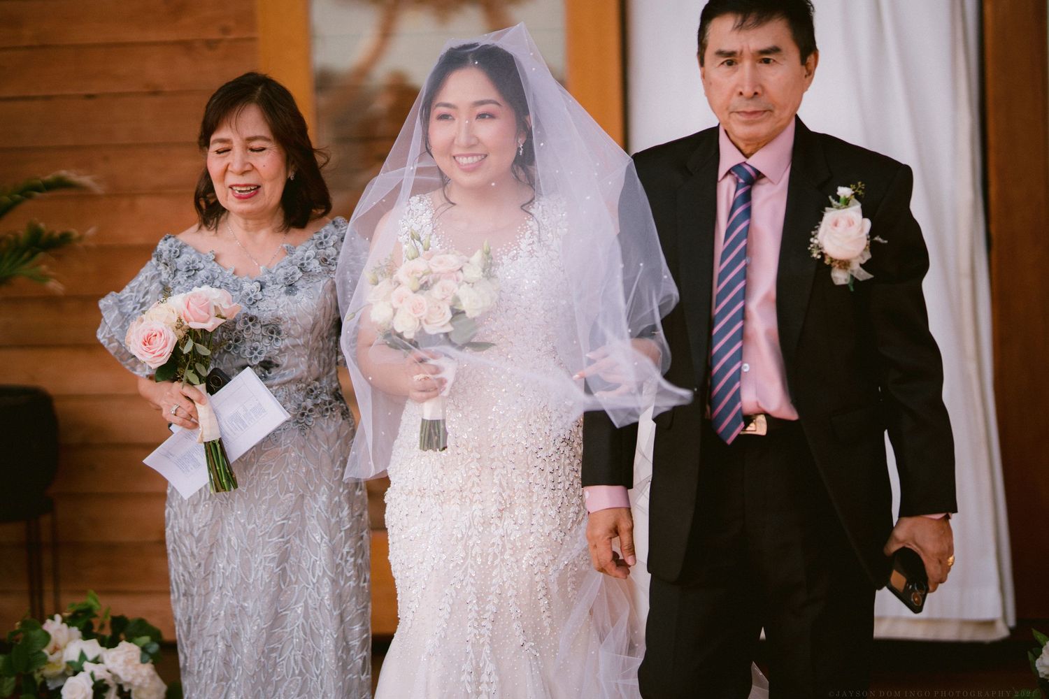 Wedding ceremony in rustic wooden venue with elegant floral decorations.