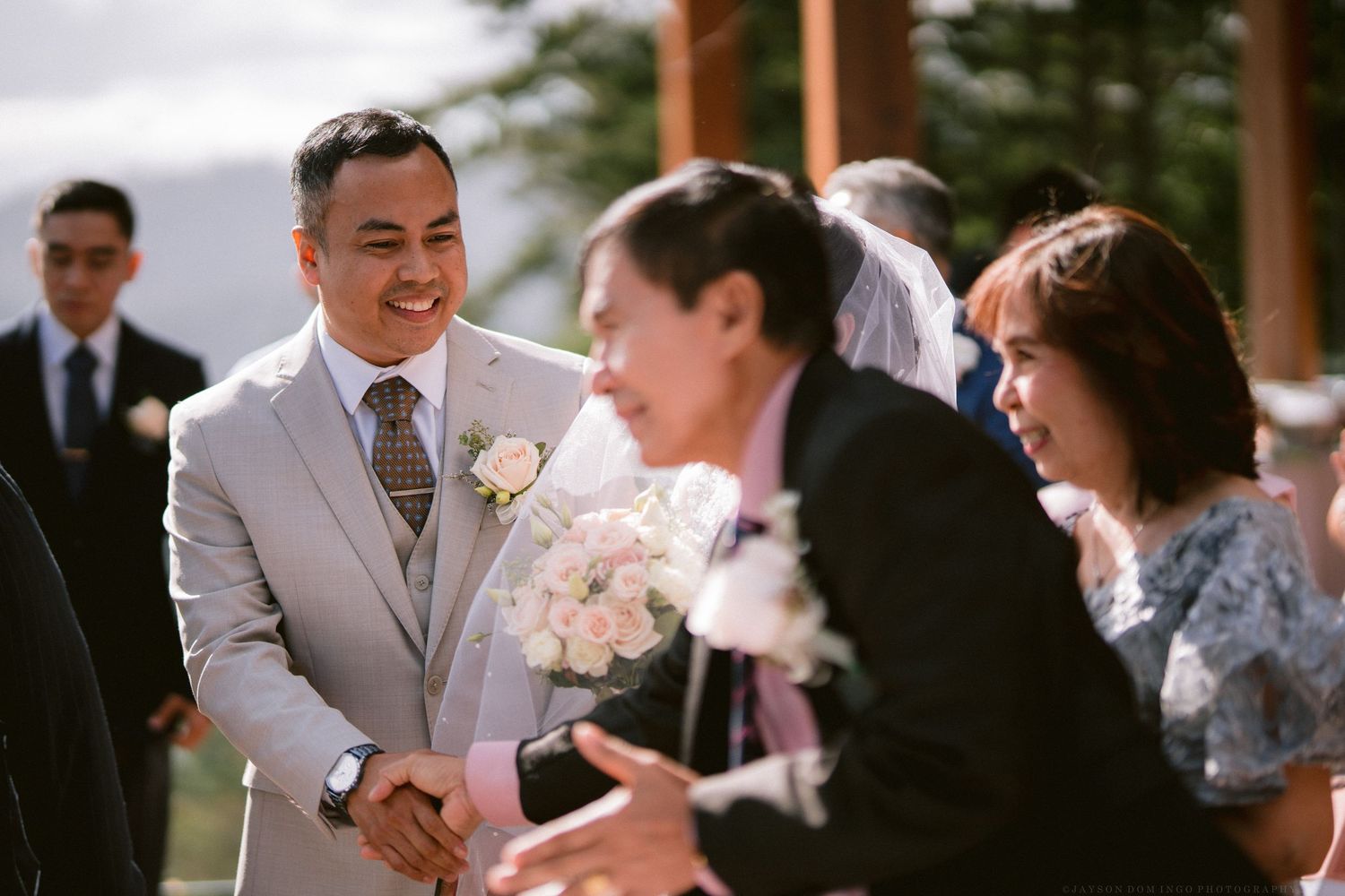 Wedding party members sharing joyful moments during an outdoor celebration.