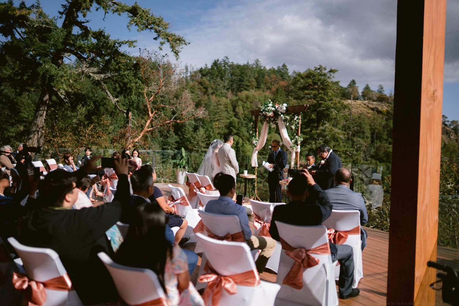 Wedding guests watching ceremony with mountain landscape in the background.