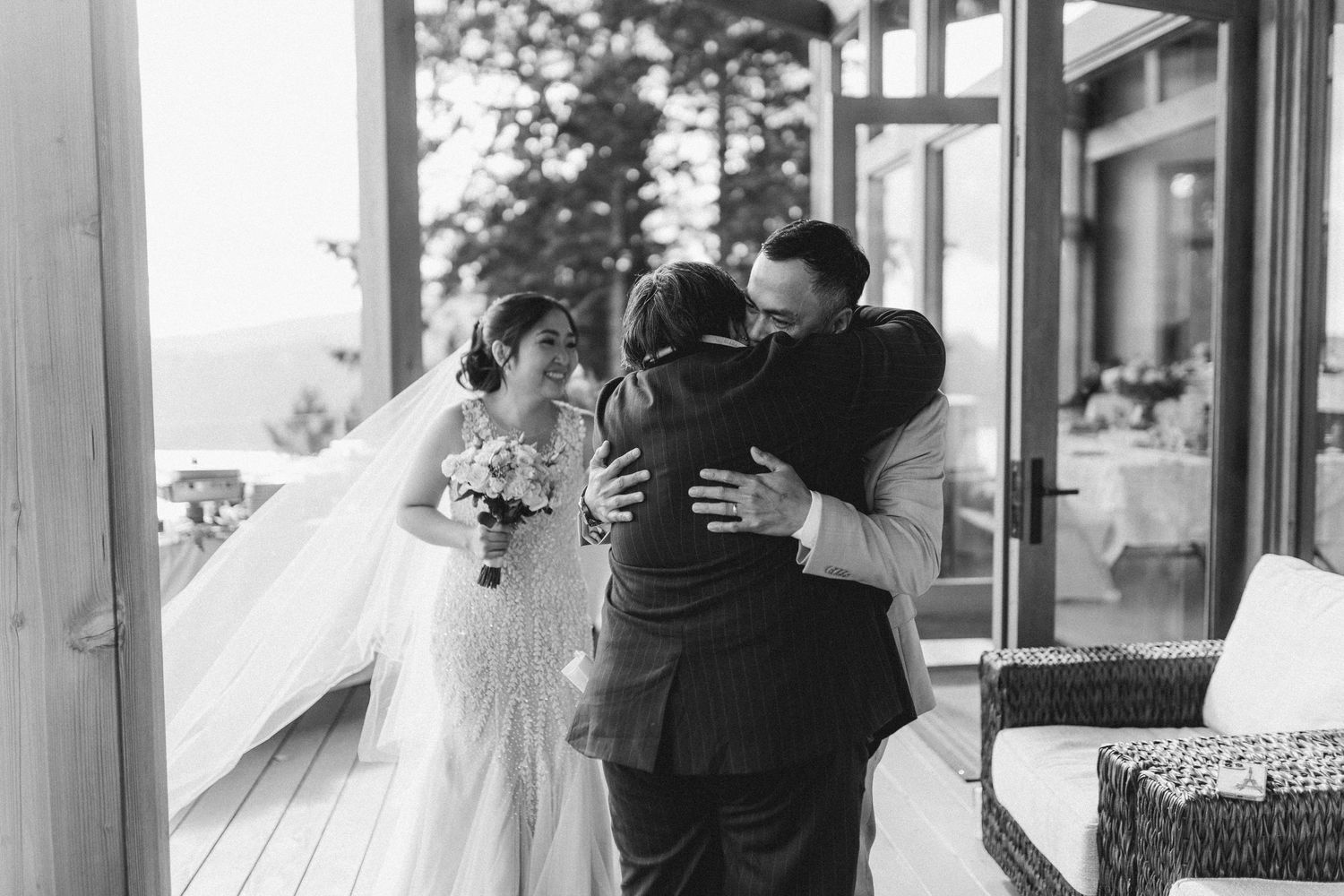 Wedding couple walking along a covered outdoor corridor with natural lighting.