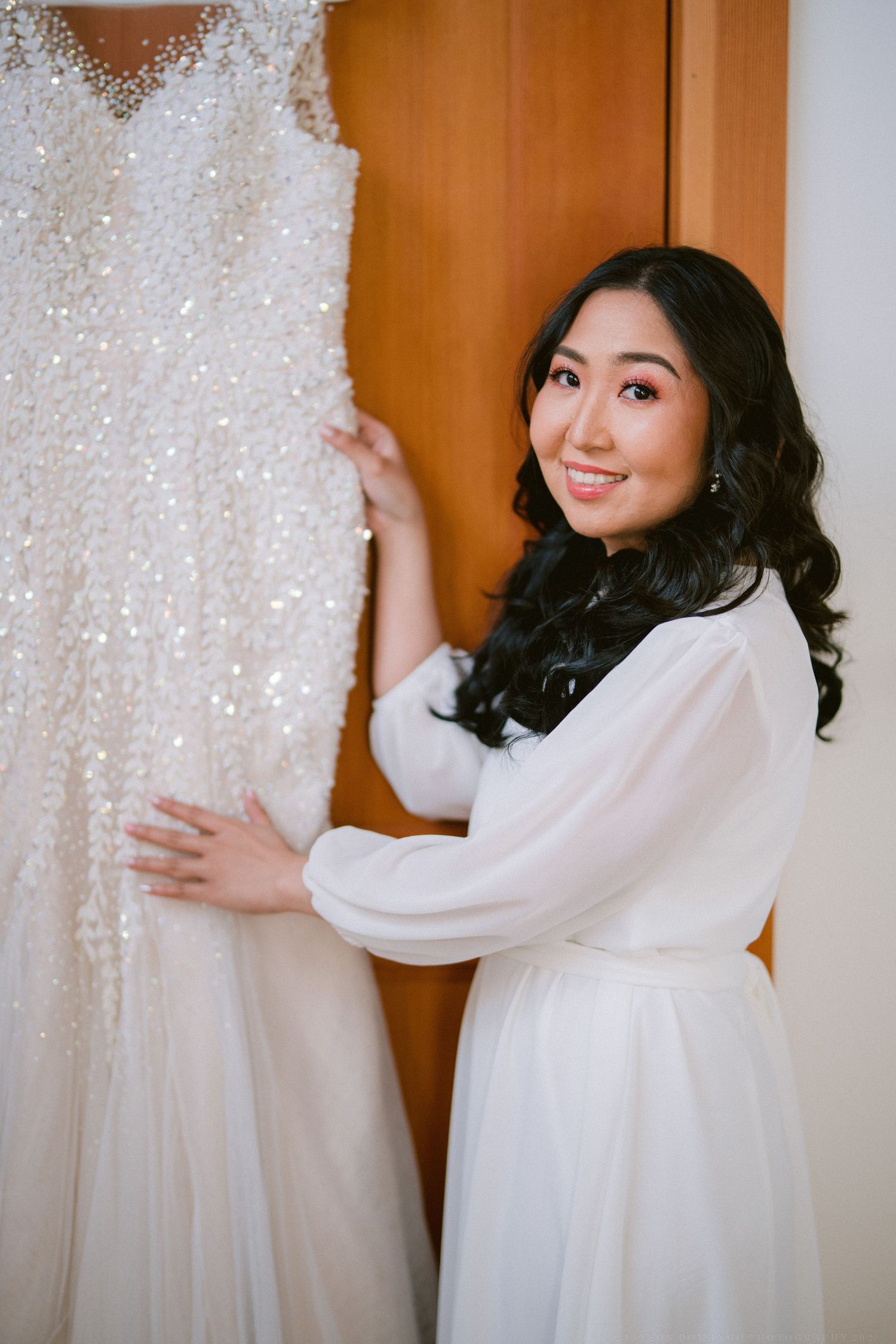 A sparkling wedding dress hangs on display as preparations begin for the big day.