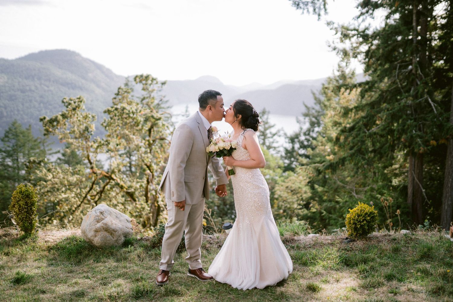 Newlyweds share an intimate moment on a scenic mountain vista during their outdoor wedding.