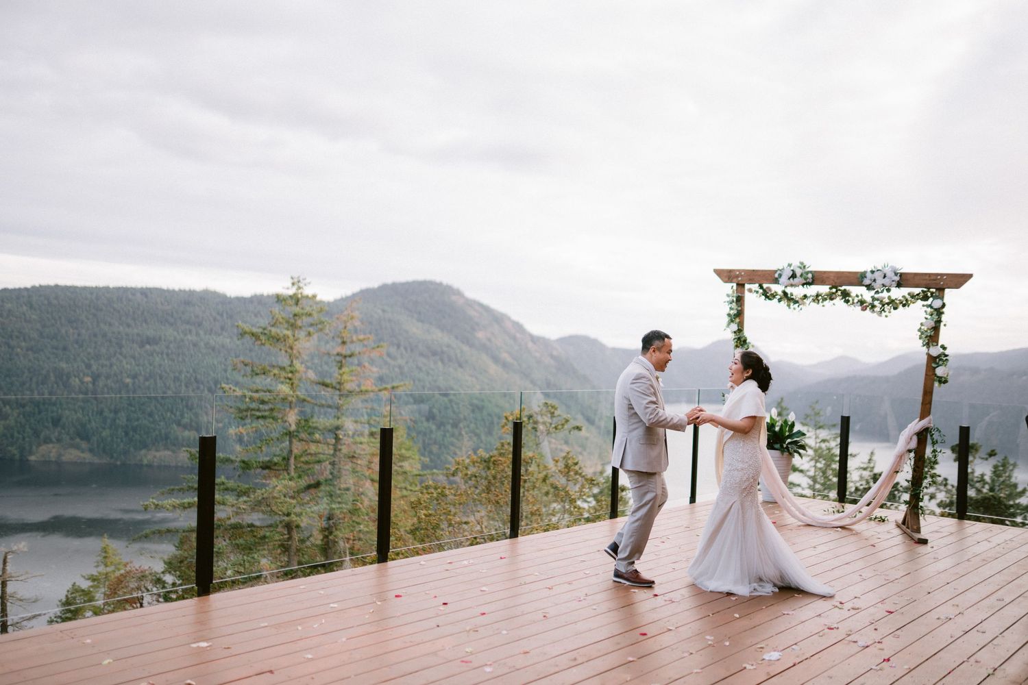 Scenic mountain deck overlooking a lake with decorative floral arch for an outdoor wedding ceremony.