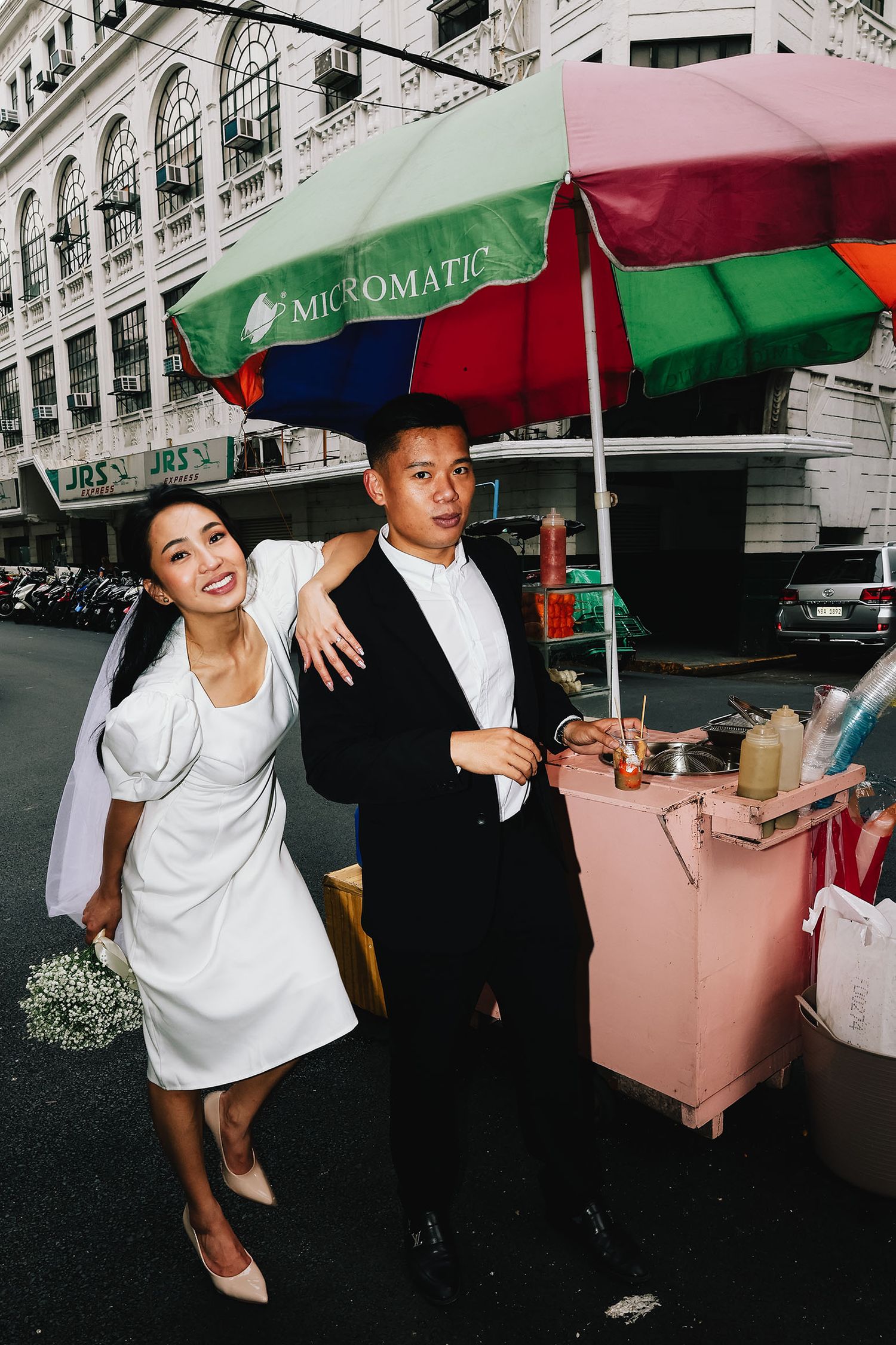 A playful series of photos showing people in white shirts dancing and holding pink boxes on a city street.