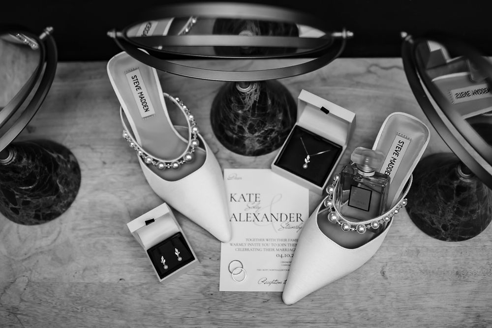 Black and white photograph showing a collection of name cards and glasses arranged on a table surface.