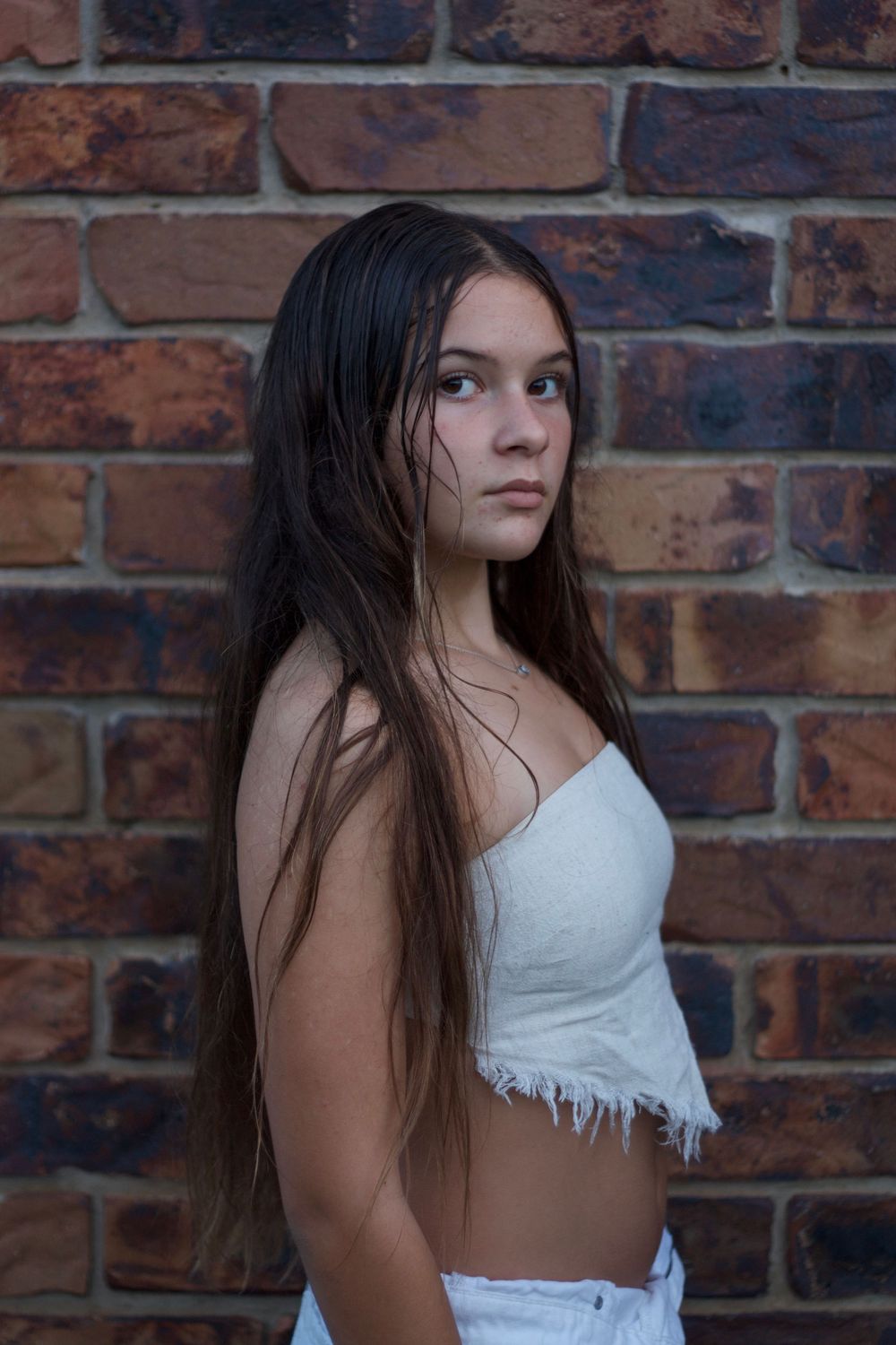 Portrait series against a rustic brick wall showing different poses and expressions.