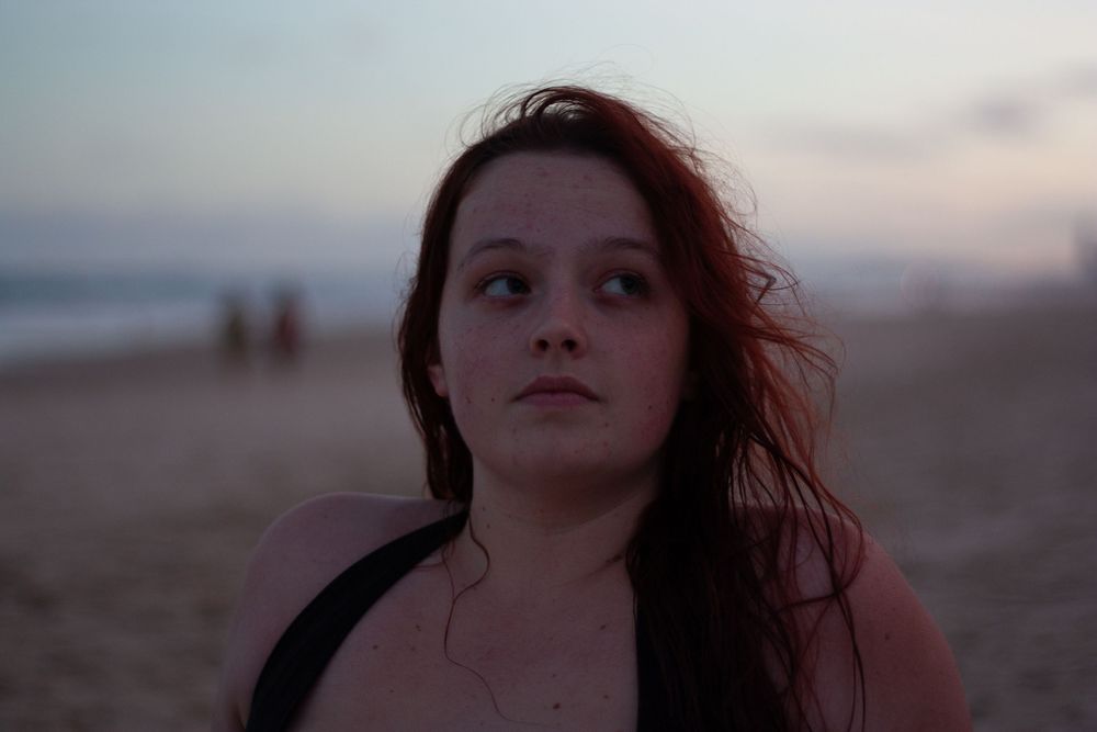 Atmospheric beach portraits captured during sunset with moody lighting.