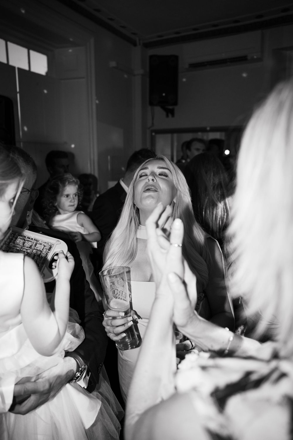 A series of black and white party photos showing people dancing and celebrating in a crowded indoor space.