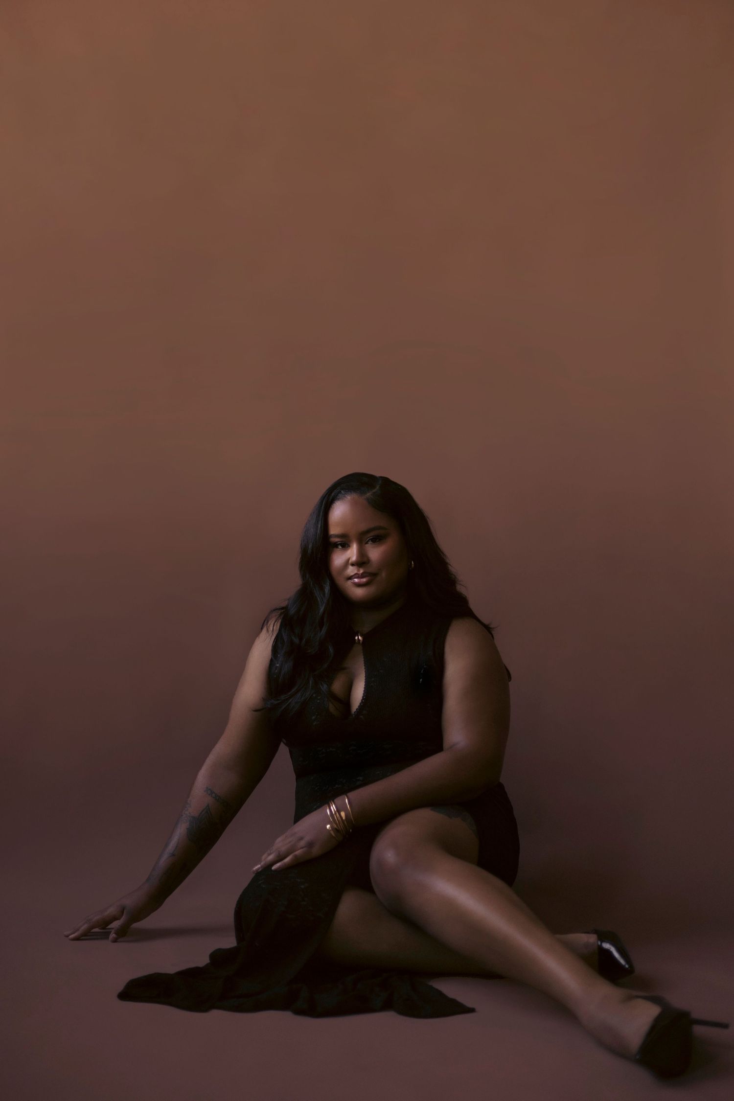 Artistic portrait series showing a person in black attire posing gracefully against a dark brown studio backdrop.