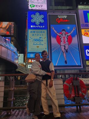 The iconic Glico Running Man sign illuminates the vibrant Dotonbori district in Osaka at night.