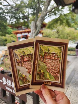 A series of Japanese ema prayer plaques displayed at a shrine showing traditional wooden designs and calligraphy.