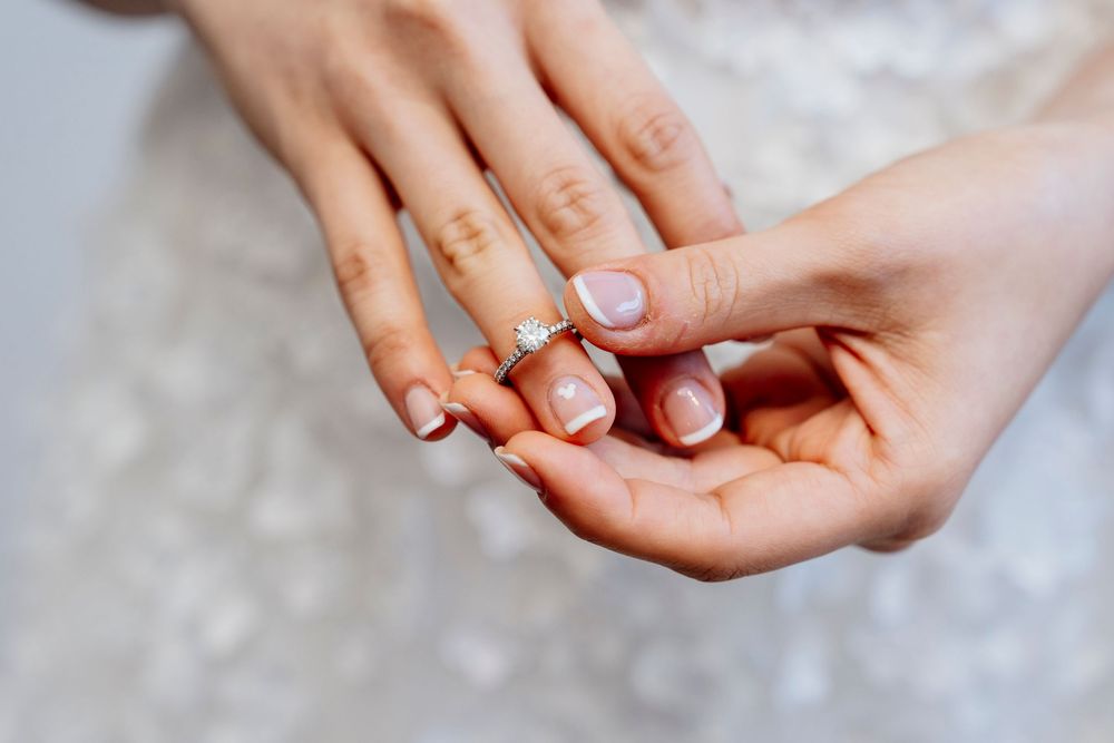 Close up view of hands wearing engagement ring