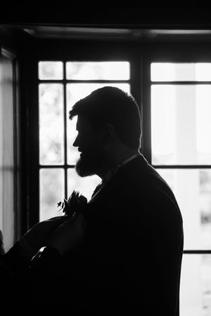 Silhouetted profile views showing figure against bright window in dramatic black and white