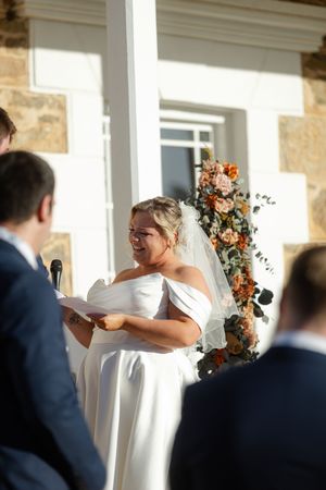 Wedding ceremony with couple sharing laughter while reading vows.