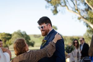 Wedding guests gather on a sunny lawn to celebrate the newlyweds.