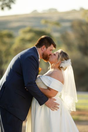 Romantic wedding couple embraces in a series of tender moments against a golden sunset backdrop.