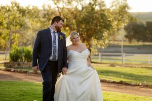 Golden hour wedding photo on lush green lawn with natural sunlight.