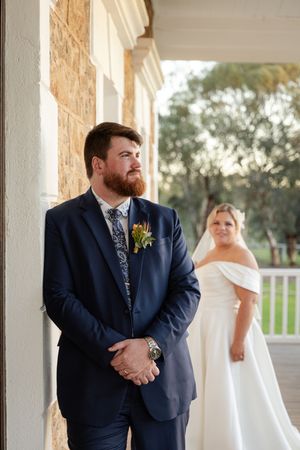Wedding couple having first look moment in rustic columned venue.