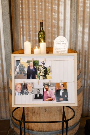 Vintage family photos displayed on a rustic wooden barrel with candles.
