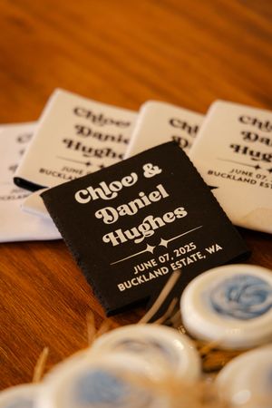 Black and white wedding name cards with text displayed on a wooden surface.