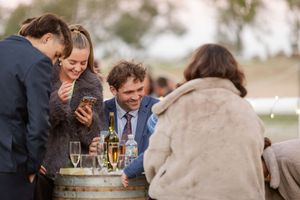 Wedding guests enjoying champagne and conversation during outdoor reception.