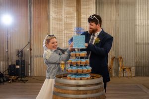 Couple cutting their wedding cake in a rustic wedding venue