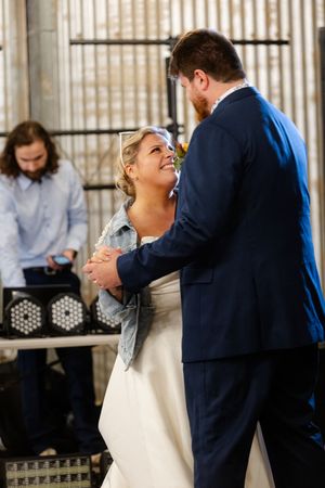 Candid moments of joy captured during indoor wedding reception dance.