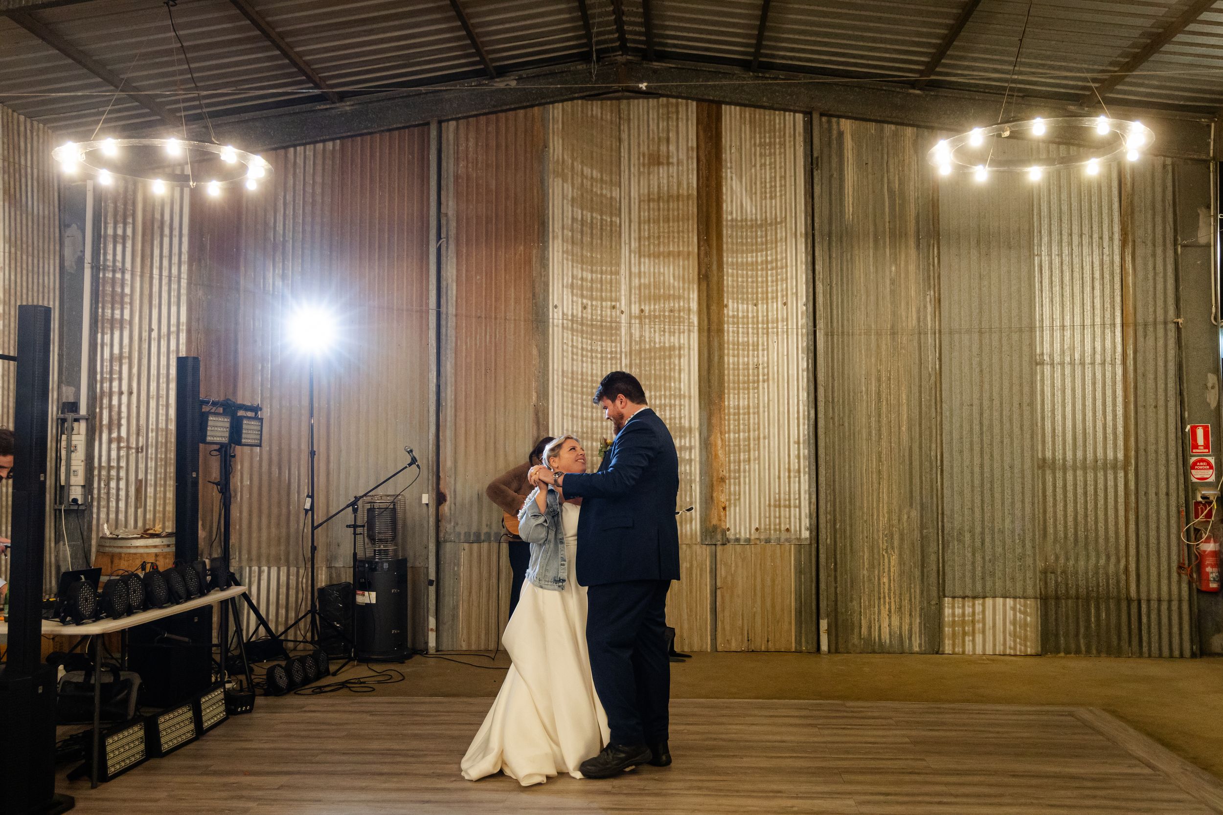 Wedding venue interior with metal walls and string lights creating romantic ambiance.