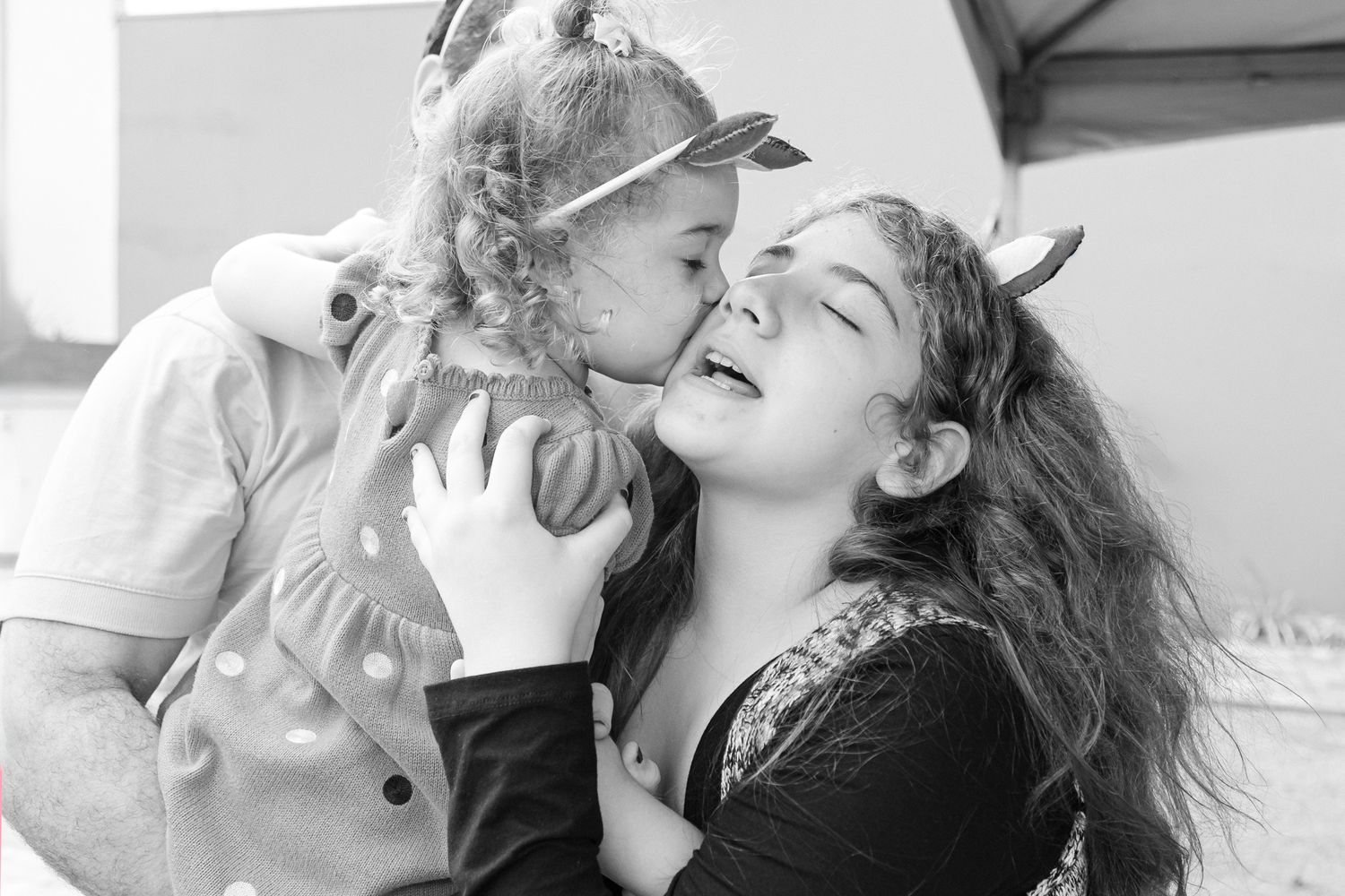 A person shares an intimate kiss with their dog, showing a sweet moment of affection between pet and owner.