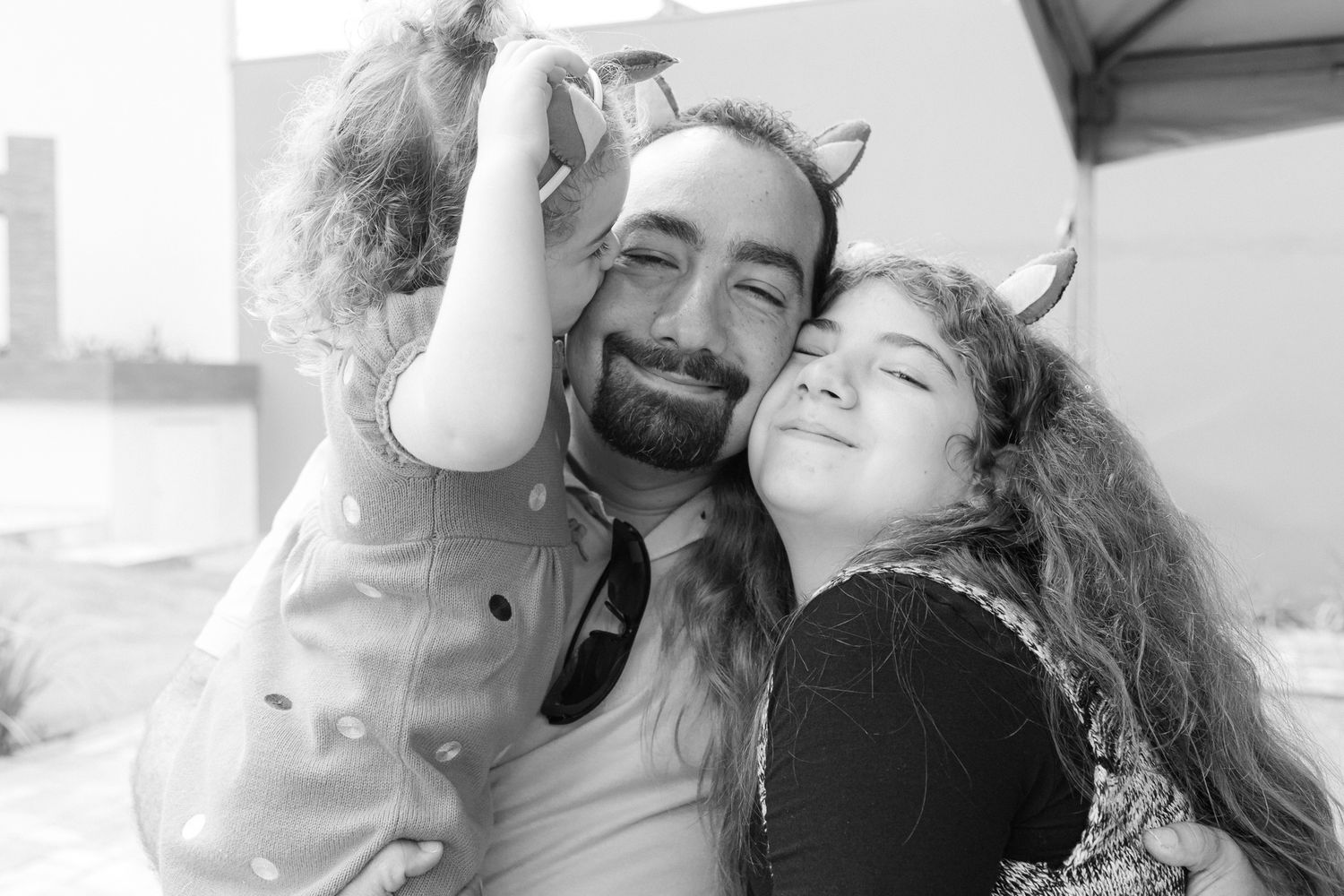 A series of black and white romantic photographs showing tender moments between a couple on a bright sunny day.