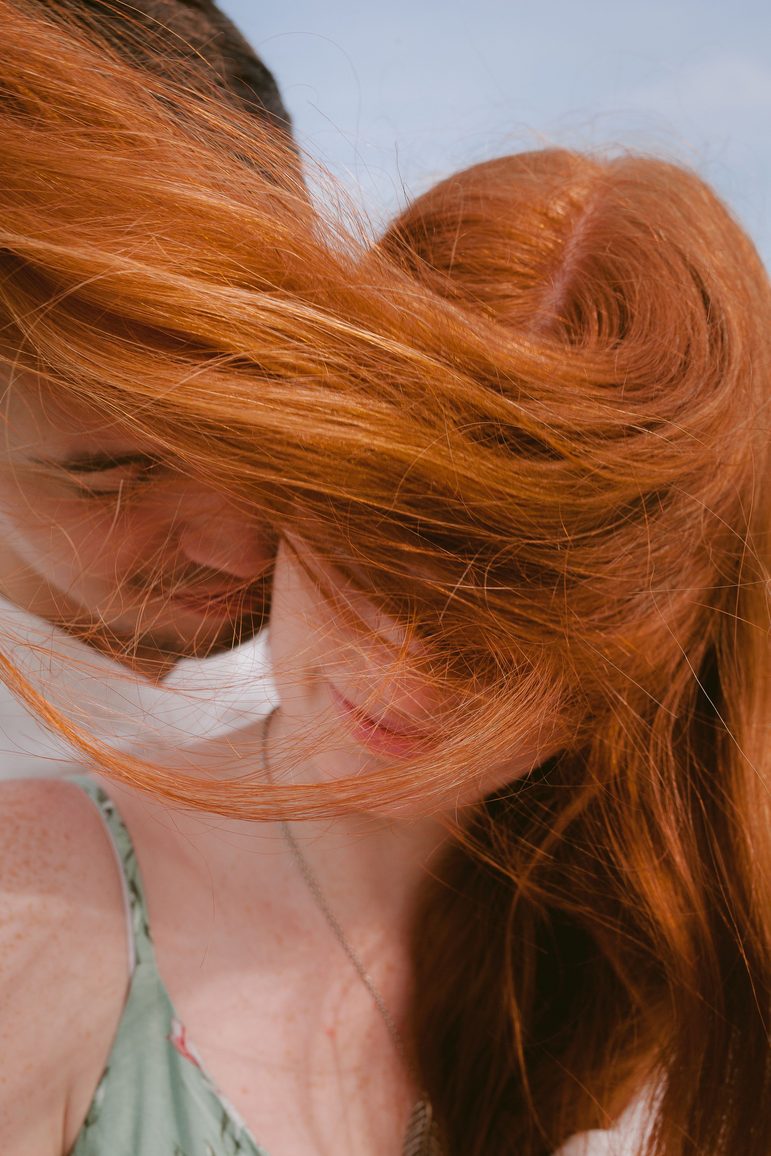 Close-up sequence showing vibrant red hair flowing and moving against a light background.