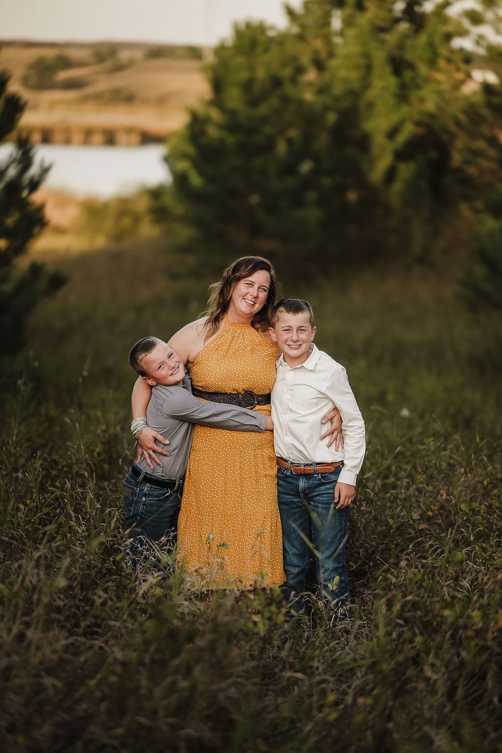 Family portrait session in a wildflower meadow at golden hour showing joyful candid moments and warm interactions.