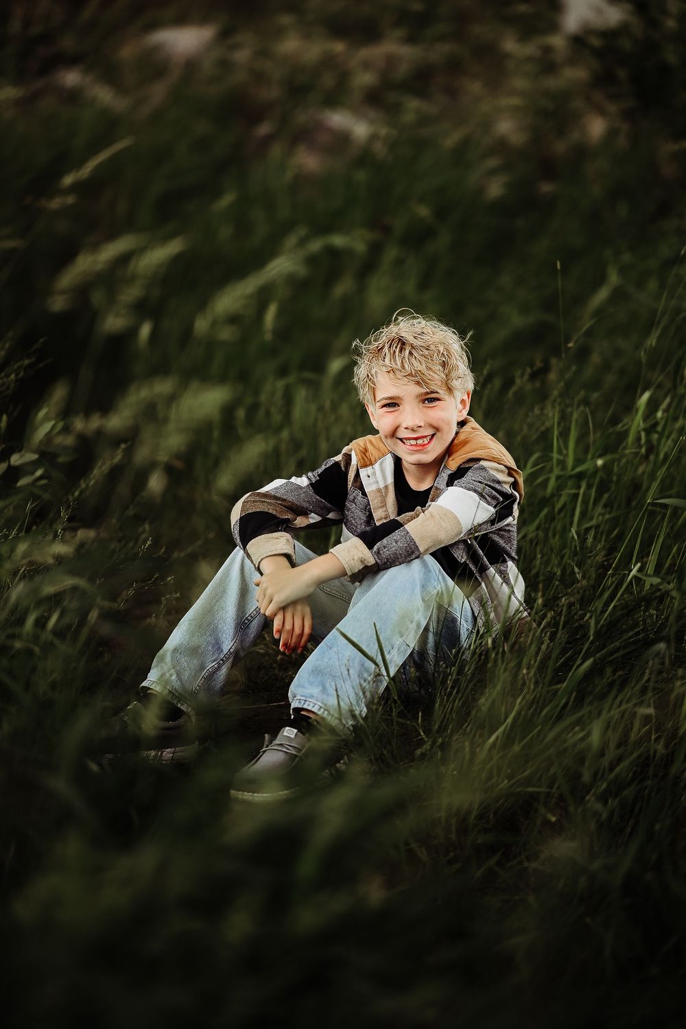 A joyful moment captured in tall grass at golden hour with natural outdoor lighting and shadows.