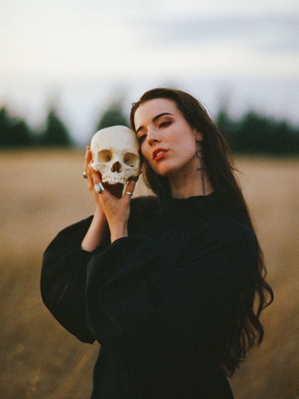 A series of moody portraits showing a figure with dark hair in a field at sunset holding a cigarette.