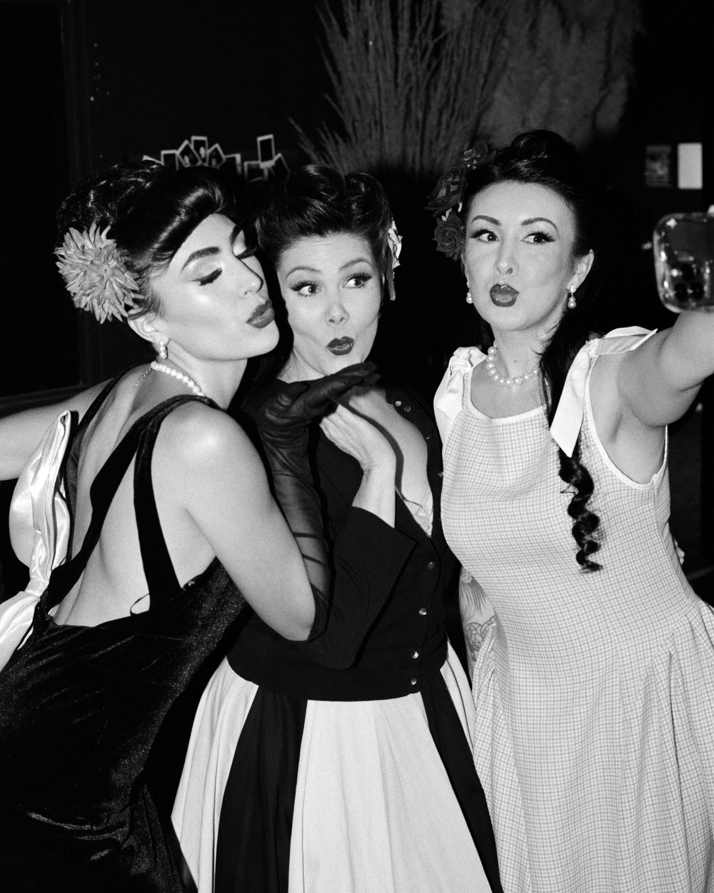 A dramatic fashion photoshoot collage in black and white showing models posing and making expressive gestures.