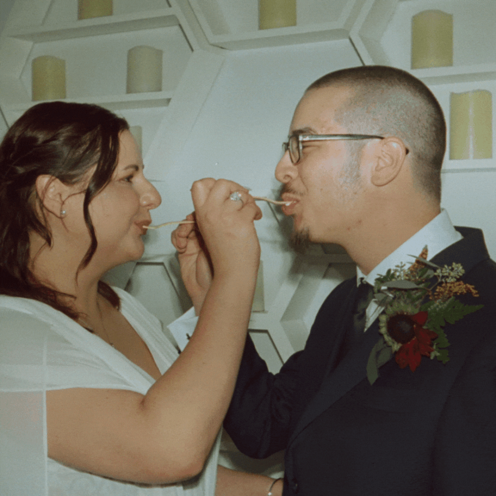 A couple shares a sweet moment feeding each other cake at their wedding reception.