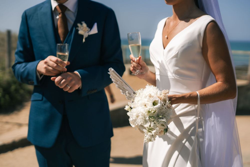 A bride and groom share an intimate moment during a beachside wedding ceremony.