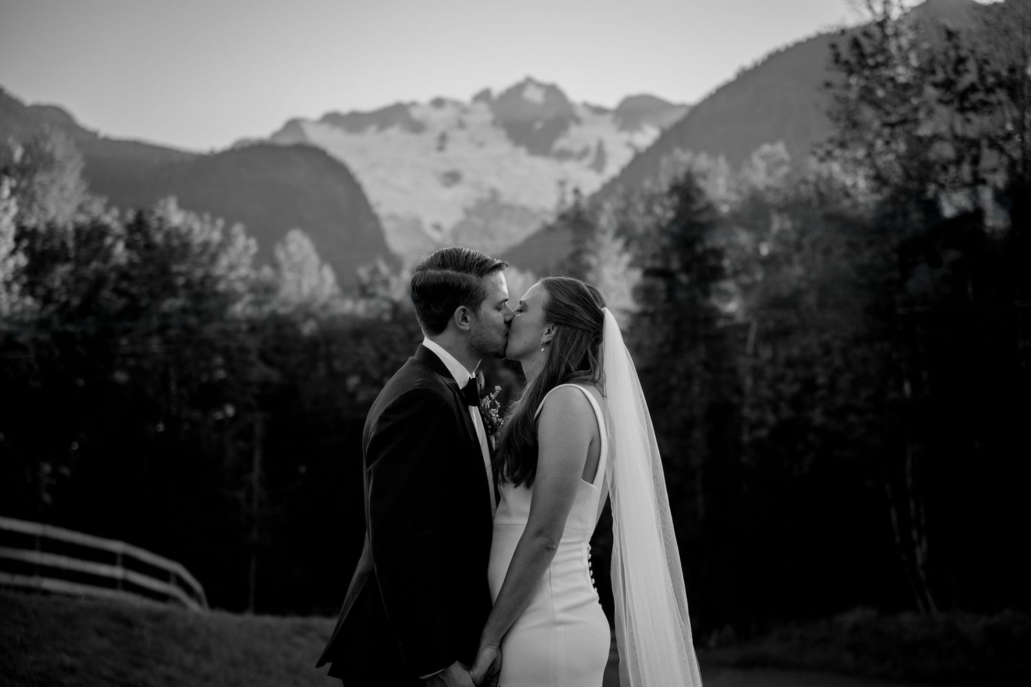 Black and white romantic mountain wedding photo sequence showing the couple embracing with dramatic peaks in background.