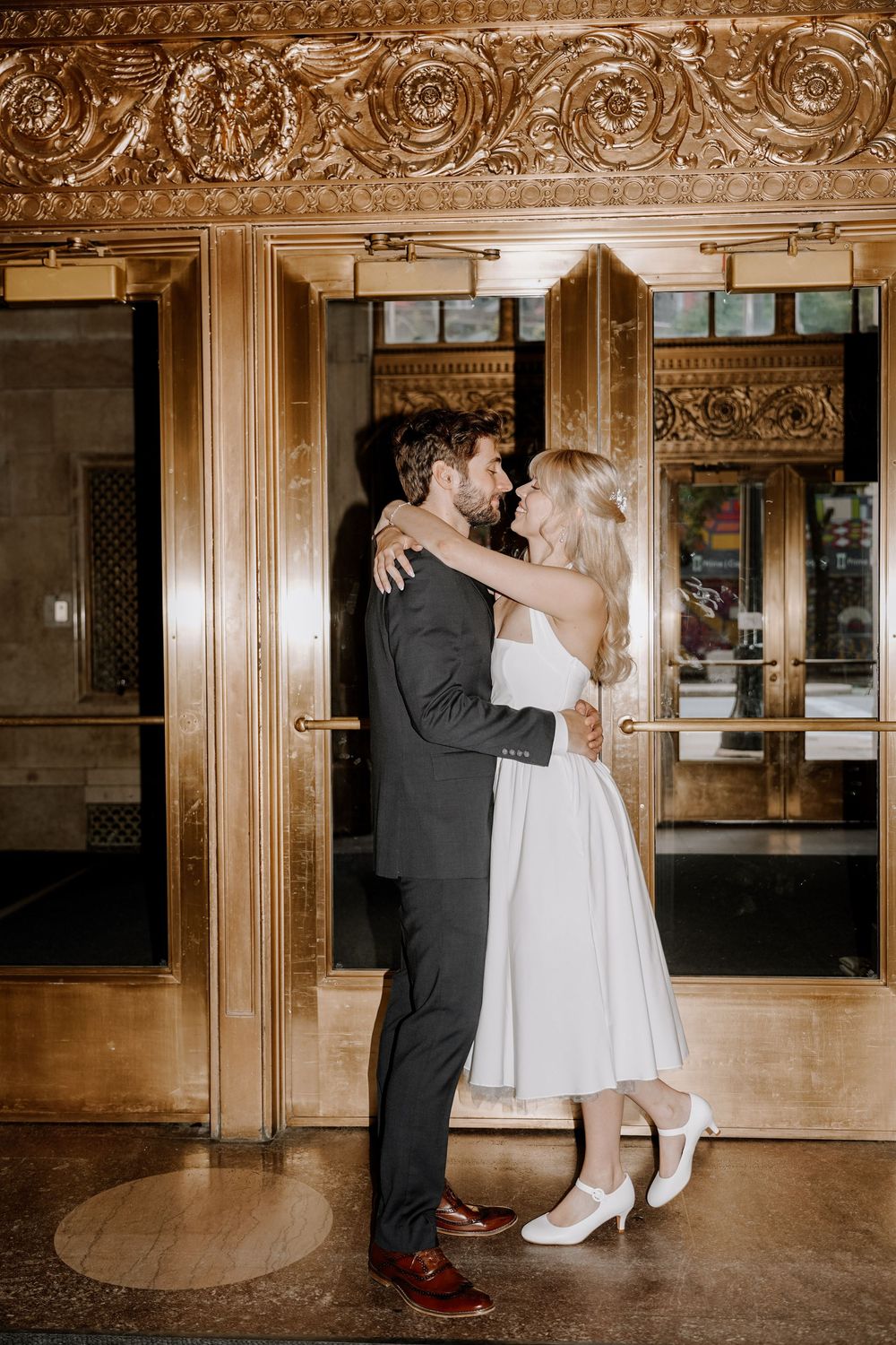 A romantic dance sequence in a grand ballroom with ornate golden decor and vintage architectural details.
