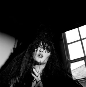 Black & white photograph showing Jessica Wilcock wearing a headdress by Jay Briggs Millinery.