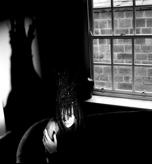 Black & white photograph showing Jessica Wilcock wearing a headdress by Jay Briggs Millinery.