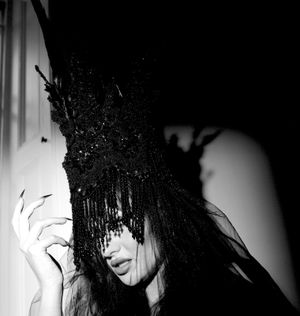 Black & white photograph showing Jessica Wilcock wearing a headdress by Jay Briggs Millinery.